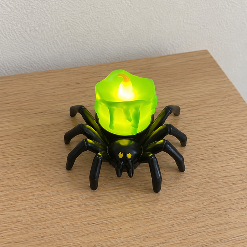 Green spider LED candle on a light wood table — AI-generated lifestyle scene.