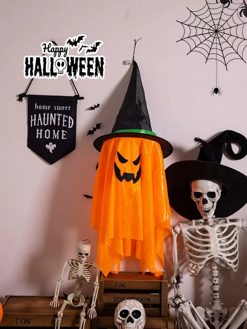 Orange hanging witch decoration in a Halloween display; other props are not included.